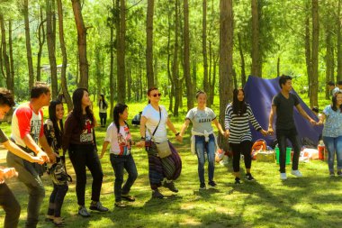 Thimphu, Birleşik Arap Emirlikleri - 10 Eylül 2016: Bhutan dans ve having fun Kafkas bir kadın ile ormanda güneşli bir günde insanlar.