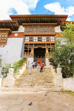 : Paro, Bhutan - 10 Eylül 2016: Eski tapınak merdivenlerde durup turist düşük açılı görünüş.
