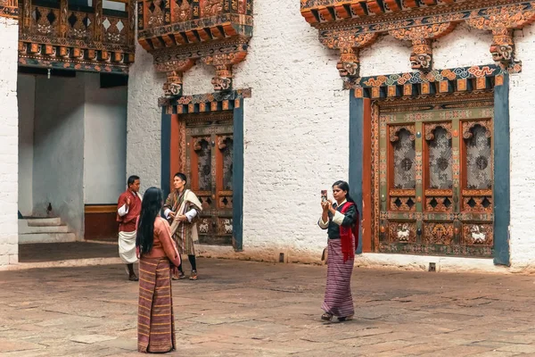 Thimphu, Bután - 10 de septiembre de 2016: Los butaneses locales visten ropa tradicional en el patio trasero de un templo . — Foto de Stock