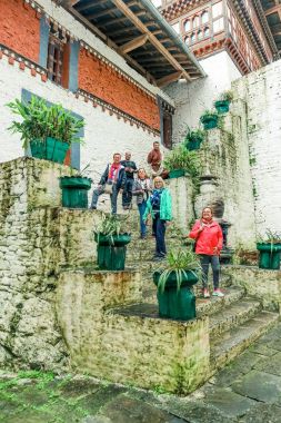 Trongsa, Birleşik Arap Emirlikleri - 12 Eylül 2016: Mutlu turist grubu ayakta Trongsa Dzong, Bhutan avlusunda merdivenlerde