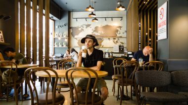 Istanbul, Türkiye - 02 Haziran 2017: Genç adam Starbucks coffee shop Istanbul'da.