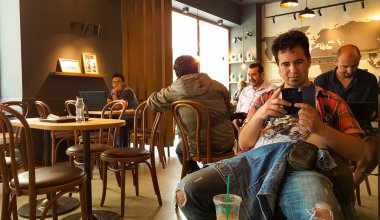 Istanbul, Türkiye - 02 Haziran 2017: Genç adam Starbucks coffee shop Istanbul'da.