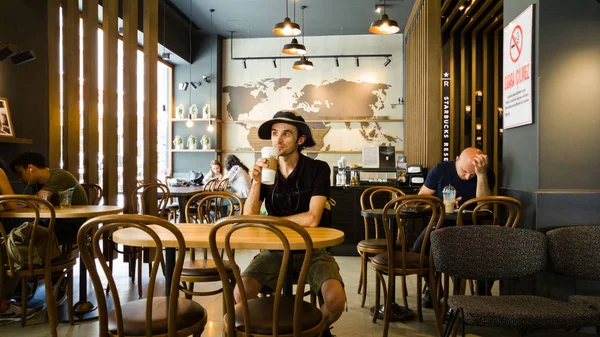 Istanbul, Türkiye - 02 Haziran 2017: Genç adam Starbucks coffee shop Istanbul'da.
