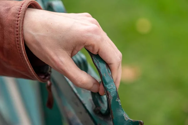 Detalle de la mano femenina sosteniendo la puerta de metal en el jardín —  Fotos de Stock