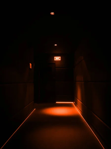 Couloir sombre vide éclairé de lumières orange dans un bâtiment — Photo