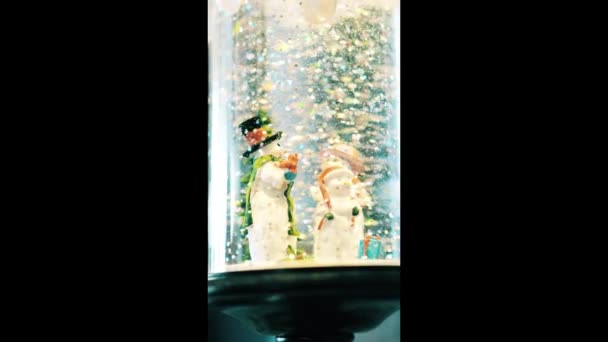 Kristálygömb tele hóemberrel és mesterséges hóval. Karácsonyi és téli koncepció. — Stock videók