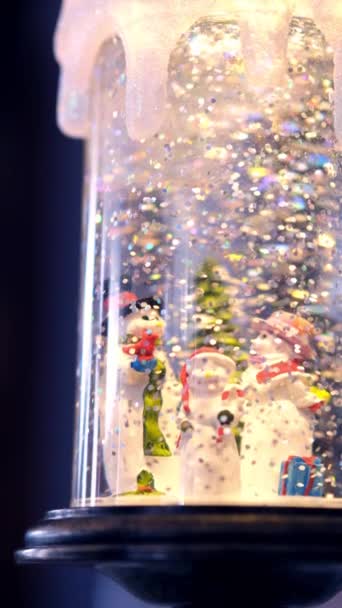Juguete cilindro de cristal lleno de muñecos de nieve y nieve artificial. Concepto de Navidad e invierno . — Vídeo de stock