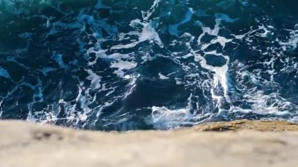 Powolny ruch fale morskie z białą pianką łamanie na skałach na plaży — Wideo stockowe