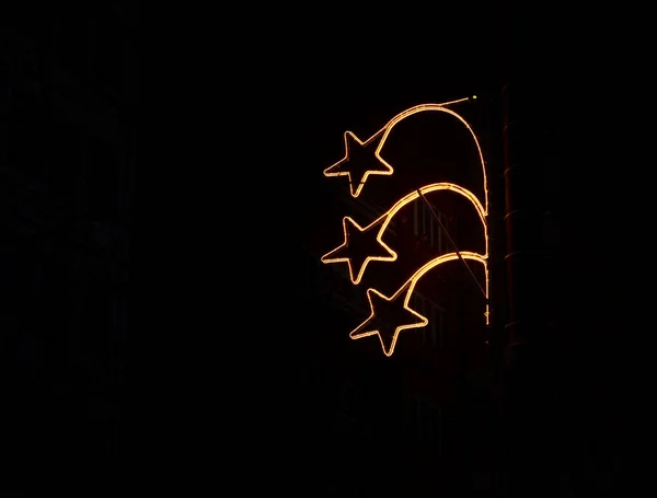 Decoratieve stervormige wintervakantie decoraties op straatpaal in het donker — Stockfoto