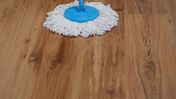 Front view of a flat wet mop wiping slowly back and forth the parquet in the living room — Stock Video