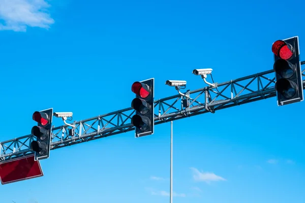 Red traffic lights and cameras against the blue sky on the highway in Istanbul, Turkey.