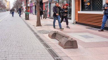 Eskisehir, Türkiye - 23 Mart 2020: Corona günlerinde insanlar sokakta yürüyor. Büyüklerin oturmasını önlemek ve onları evde tutmak için metropolitan belediyesi tarafından ayrılmış bir bank..