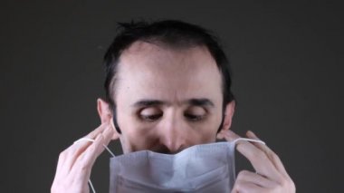 Bulaşıcı hastalıklara karşı korunmak için beyaz tıbbi maske takan beyaz bir adam, koronavirüs.