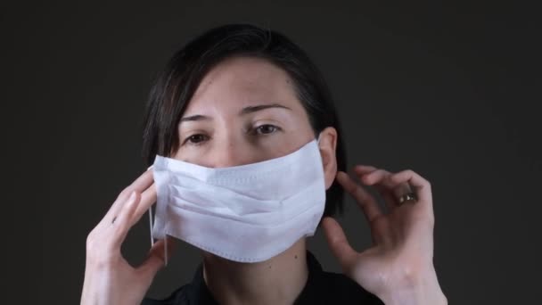 Portrait of a Caucasian woman wearing a white medical mask for protection against contagious disease, coronavirus — Stock Video