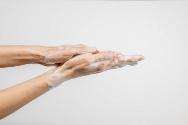 Beyaz arka planda ellerini yıkayan beyaz bir kadın var. El yıkama gösterisi. Hijyen ve önleme koronavirüsü kavramı.