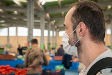 Türkiye 'nin Eskişehir kentinde Corona günlerinde geleneksel market pazarında tıbbi maske takan bir Türk esmerinin portresi.