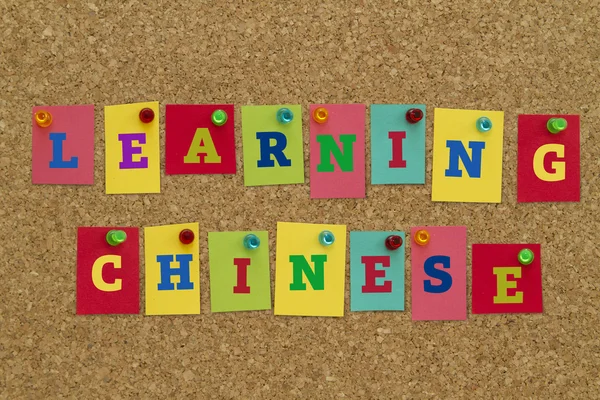 learning CHINESE inscription on colorful sticky notes pinned on cork board.