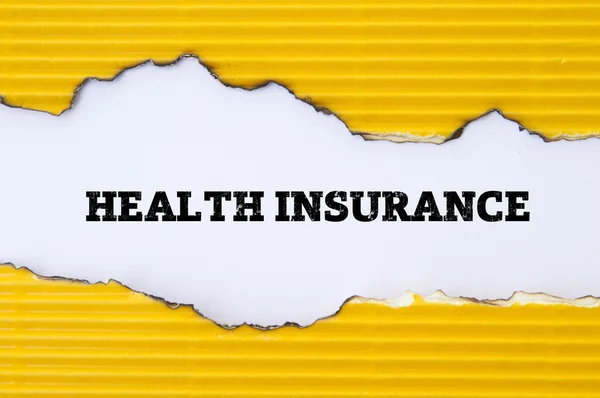 黄色の段ボールの穴の中の健康保険の碑文 — ストック写真
