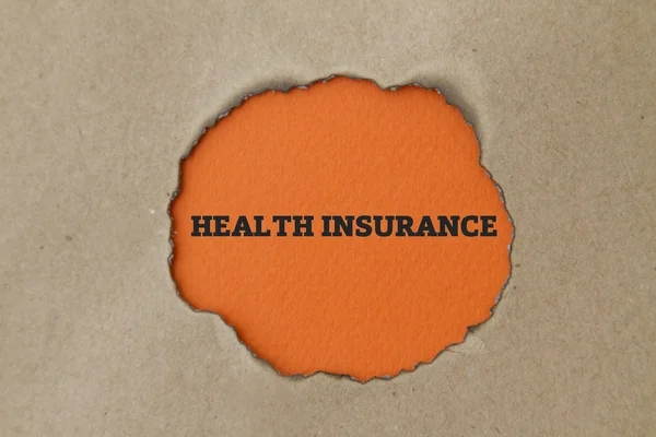 段ボールの穴の中の健康保険の碑文 — ストック写真