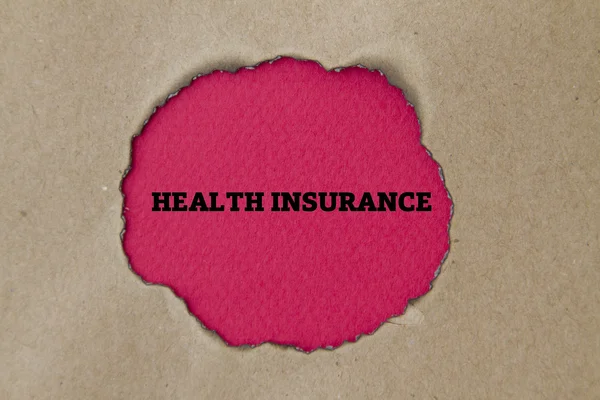 段ボールの穴の中の健康保険の碑文 — ストック写真