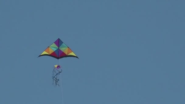Renkli uçurtma uçan mavi gökyüzü güneşli gün özgürlük ışık sembolü — Stok video