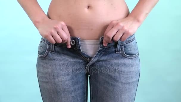 Woman trying to close too tight blue jeans. Belly fat and time to go on a diet — Stock Video