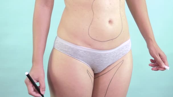 Mujer dibujando en su cuerpo líneas de cirugía plástica para adelgazar y reducir la grasa — Vídeos de Stock