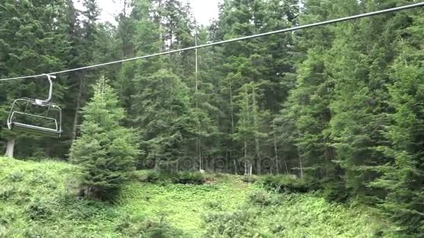 Stoeltjeslift zonder mensen tijdens de zomertijd in berg hout — Stockvideo