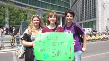 Milan, İtalya - 24 Mayıs 2019 Mutlu kızlar küresel iklim grevinde gösteri yapıyorlar. Öğrenciler okuldan yeşil pankartlarla kaytarıyor, Cuma günü gülümseyen genç kadınlar, çevre bilimci hareketi