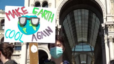 Milan, İtalya - 15 Mart 2019: Kirlilik maskeli çocuk küresel iklim grevinde grev yapıyor. Elinde 