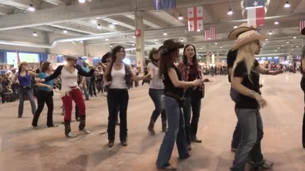 クレモナ イタリア 5月2019サークルカウボーイ音楽 カントリーフェスティバルでのラインダンスで踊るカップル 女性と男性が一緒にステップ デュオ振付を持つ人々 アメリカの伝統 ジーンズブーツフラグ — ストック動画