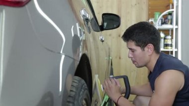 Çalışan bir araba baca şapkası ile elektrikli alet parlatıyor. Araba serisi detaylandırma.