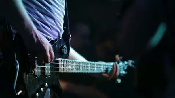 Музыкант играет на бас-гитаре — стоковое видео