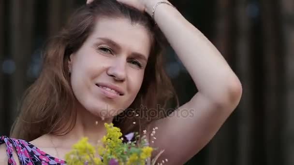 Bela mulher inspirada mantém um buquê de flores silvestres . — Vídeo de Stock