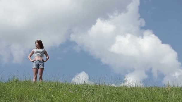 Счастливая женщина на зеленом весеннем поле против голубого неба. Свобода и счастье — стоковое видео