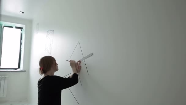 Diseñador para hacer un dibujo en una pared blanca en el interior — Vídeos de Stock