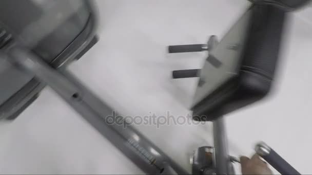 Point de vue. Homme faisant de l'exercice sur la machine de fitness dans la salle de gym 