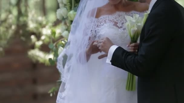 Op een trouwdag zet bruidegom een trouwring op de vinger van een bruid. — Stockvideo