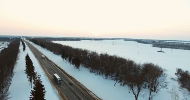 Luftaufnahme von Lastwagen und Autos, die sich auf winterlichen Straßen bewegen. 4k — Stockvideo