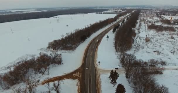 Несколько машин едут по ледяной дороге в сумерках. Съёмки с воздуха . — стоковое видео