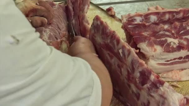 Rzeźnik kroi świeże surowe mięso — Wideo stockowe
