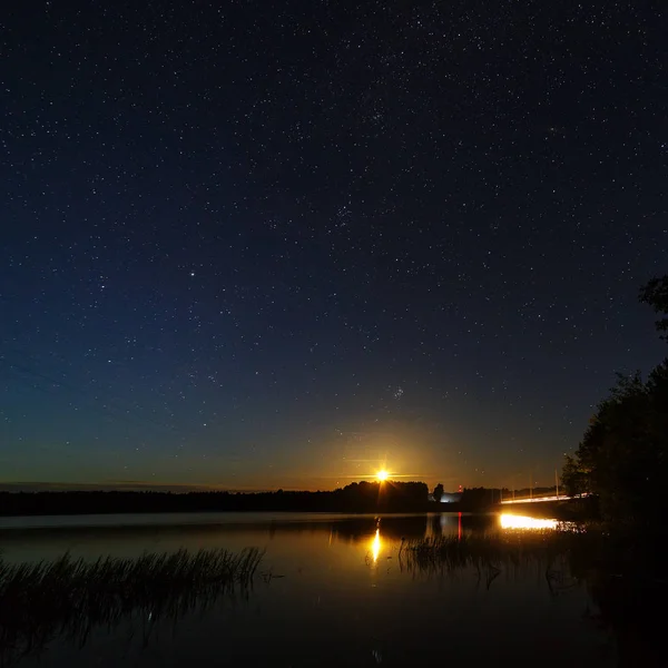 The stars in the night sky over the river.