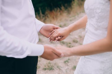 Düğün çifti el ele tutuşuyor.