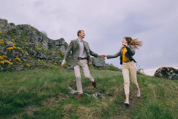 Joven pareja corriendo en las montañas — Foto de Stock