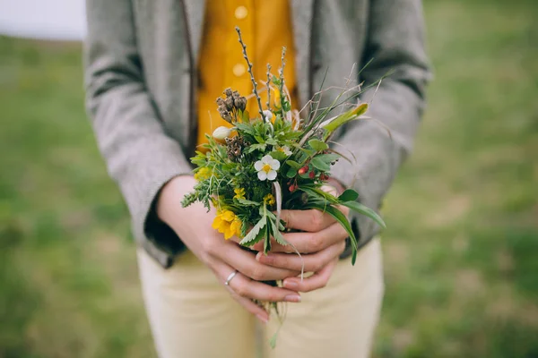 Bouquet van veldbloemen in handen — Stockfoto