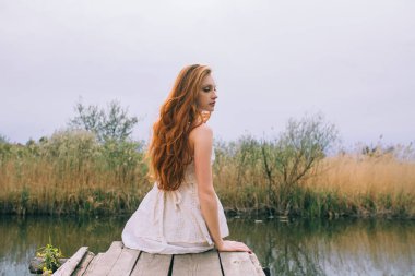 Rıhtımda Kızıl saçlı kadın