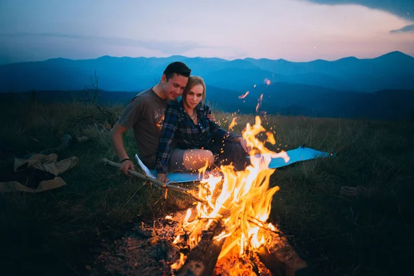 Paar sitzt am Lagerfeuer — Stockfoto