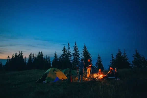 Les gens campent près de la cheminée sur la nature — Photo