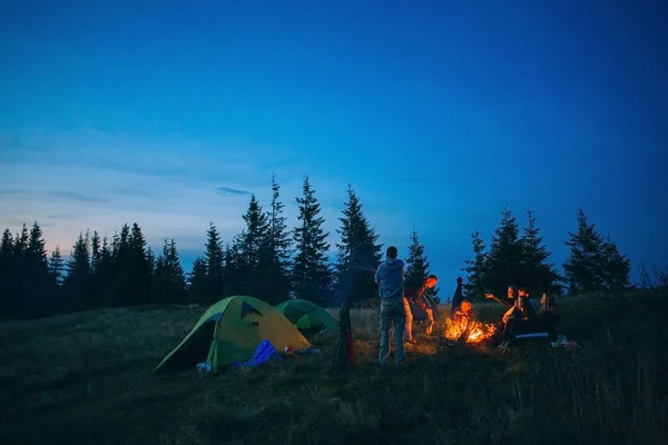 Gente acampando cerca de chimenea en la naturaleza — Foto de Stock