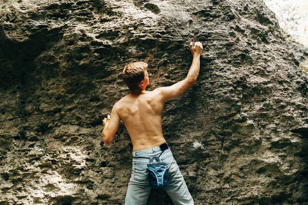 Человек карабкается по скале — стоковое фото